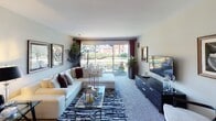 Located at 17W720 Butterfield Rd in Oakbrook Terrace, Illinois, this single-floor residence offers a well-designed layout that balances comfort and functionality across multiple living spaces. The expansive living room is a standout feature, highlighted by large sliding glass doors that flood the space with natural light and provide direct access to an outdoor patio with lush greenery views. Plush carpeting and a generous footprint make this room ideal for both relaxing and entertaining. A second living or flex space offers additional versatility, also benefiting from a large window overlooking the landscaped surroundings. The dining area sits adjacent to the kitchen, anchored by a pendant light fixture and seamlessly connected for easy entertaining. The kitchen is well-appointed with warm wood cabinetry, dark granite countertops, hardwood flooring, and stainless steel appliances. The primary bedroom is generously sized with carpeted floors, mirrored sliding closet doors, and natural light from a large window. Its en-suite bathroom features a dual-sink vanity with wood cabinetry and a separate bathing area. A second full bathroom mirrors this functional design with tile flooring and a clean, neutral palette throughout. This residence offers a cohesive and comfortable living environment in a well-established Oakbrook Terrace location.