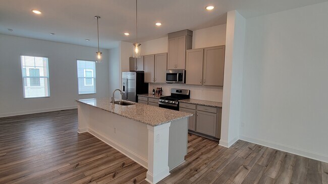 Impresionante cocina con estufa a gas, isla y mucho espacio de almacenamiento. - 506 Village Branch Ln