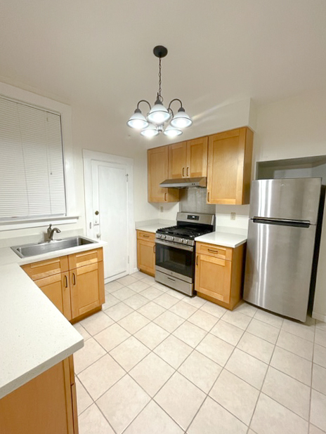 Kitchen with updated cabinets and counters, stainless steel appliances, gas range - 1017 Hyde St