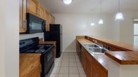 Located at 111 W Marshall St in Richmond, Virginia, this single-floor unit offers a well-designed layout with a clean, contemporary aesthetic throughout. Light-toned hardwood flooring runs consistently across the main living and bedroom areas, creating a bright and cohesive feel.

The open living area is spacious and airy, with natural light streaming in through multiple windows. A modern railing detail separates the living space from the stairwell, adding an architectural touch. The kitchen features warm wood cabinetry, a butcher block-style peninsula counter, black appliances including a refrigerator, range, and microwave, a double-basin sink, and pendant lighting overhead. Tile flooring grounds the kitchen area distinctly from the rest of the unit.

The bedrooms are generously sized with neutral walls and hardwood floors. One bedroom includes a closet and a large window overlooking the urban surroundings, while another corner bedroom benefits from dual windows filling the room with natural light and offering views of Richmond's brick-clad cityscape.

The bathrooms are finished with tile flooring, a tub-shower combination, wood cabinetry above the toilet, and a round mirror. One bathroom features a window with street views, adding natural light to the space. Overall, the unit presents a functional and well-maintained living environment in the heart of Richmond.