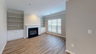 Located in Charlotte, NC, this well-appointed one-bedroom, one-bathroom home offers a thoughtfully designed single-floor layout with warm wood-look flooring carried throughout. The open-concept living room is a standout, anchored by a classic fireplace with a white mantle, flanked by built-in shelving and cabinetry, and bathed in natural light from a large window with blinds. Crown molding adds an elegant finishing touch to the space.

The kitchen is both functional and stylish, featuring granite countertops, white cabinetry, a peninsula with bar seating, stainless steel appliances including a refrigerator, dishwasher, range, and microwave, as well as a double-basin sink. The layout flows seamlessly into the living area, making it ideal for everyday living.

The spacious primary bedroom includes a ceiling fan, a generous window overlooking the outdoors, and access to a dedicated closet. The full bathroom offers a granite-topped double vanity, a tub-shower combination, and matching wood-look flooring.

Additional highlights include a dedicated laundry area and an attached single-car garage with an automatic opener, providing convenient and secure parking. The neutral color palette and clean finishes create a bright, move-in ready atmosphere throughout.