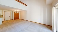 Located at 6301 Offshore Dr in Madison, WI, this two-bedroom, two-bathroom two-story residence offers a thoughtfully designed layout spread across two floors. The main level sets an impressive tone with soaring ceilings that create a bright, open atmosphere, complemented by soft carpet flooring and warm wood trim throughout the living areas. A second-floor loft railing overlooks the main living space below, adding architectural depth and visual interest.

The updated kitchen is a standout feature, showcasing white shaker cabinetry, granite countertops, a subway tile backsplash, stainless steel appliances, and a central island — all set atop durable hardwood-style flooring. The main-level bathroom features a wide vanity with white cabinetry and a tub-shower combination.

Upstairs, the spacious primary bedroom benefits from a vaulted ceiling and a skylight that floods the room with natural light. A ceiling fan and walk-in closet with built-in wood shelving add to its functionality. A built-in bookcase adds a charming detail to the second bedroom. The upper-level bathroom includes a large vanity and a glass-enclosed walk-in shower.

Both floors include dedicated laundry areas, providing added convenience. The home also features two closets and a warm, neutral color palette throughout.