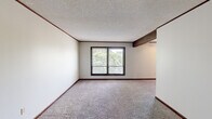 Located at 1666 Seven Pines Rd in Springfield, Illinois, this single-floor, three-bedroom, one-bathroom home offers a practical and functional layout. The interior is finished with wall-to-wall carpet throughout the living areas and bedrooms, complemented by dark wood baseboards and crown molding that add a classic touch. Textured ceilings are present throughout the home.

The spacious primary bedroom features a large sliding window with views of surrounding trees, offering a natural, serene backdrop and ample natural light. The additional bedrooms are well-proportioned, each equipped with ceiling fans with integrated lighting and windows that bring in natural light. One bedroom includes a closet with bifold louvered doors and a built-in hanging rod for convenient storage.

The kitchen is efficiently designed with warm wood cabinetry, a double-basin sink, laminate countertops, and a full-size refrigerator. It opens to an adjacent dining or pass-through counter area, supporting easy interaction between spaces.

The bathroom includes a full tub-and-shower combination with a single-piece surround. Throughout the home, dark-framed windows provide a consistent design detail, while the neutral wall tones keep the overall ambiance light and versatile. The layout makes efficient use of its footprint, providing comfortable living across all rooms.