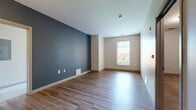 Located in the heart of downtown Columbus at 190 S High St, this 2-bedroom, 2-bathroom residence offers a thoughtfully designed single-floor layout. The open-concept kitchen serves as the centerpiece of the living area, featuring rich dark cabinetry, granite countertops, a peninsula with pendant lighting, stainless steel appliances including a dishwasher and range, and wood-style flooring that extends throughout the main living spaces. A bold blue accent wall adds a modern touch to the kitchen and living area, which is filled with natural light from large windows. Both bedrooms are carpeted and offer a quiet, comfortable retreat, with the primary bedroom providing a generous footprint. Each bathroom is finished with dark vanity cabinetry, granite countertops, a tub-shower combination with white subway tile surround, and wood-style flooring. Both bedrooms are served by walk-in closets equipped with wire shelving systems. Additional conveniences include a dedicated laundry area, a utility room, and a private balcony. A connecting hallway ties the layout together efficiently, making this a practical and stylish residence in a prime urban Columbus location.