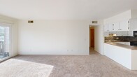 Located on Mersey Lane in Lansing, Michigan, this single-floor, 2-bedroom, 3-bathroom home offers a well-organized layout designed for comfortable everyday living. The combined living and dining area is a bright, open space with plush carpeting and a sliding glass door that fills the room with natural light and leads out to a private balcony with outdoor views. The kitchen is well-appointed with white cabinetry, dark countertops, a decorative tile backsplash, black appliances, and tile flooring, accompanied by a nearby pantry for additional storage. A welcoming entrance and hallway with tile flooring and ceiling lighting connect the main areas of the home. The two bedrooms are carpeted and generously sized, with the primary bedroom offering notable square footage, a ceiling fan, and a large window that brings in ample natural light. The three bathrooms include updated finishes such as dark-framed mirrors, dark granite countertops, tiled shower and tub enclosures, and marble-style tile flooring. A dedicated in-unit laundry room houses a full-size washer and dryer. Two closets provide practical storage throughout. The space is rounded out by a utility room, creating a fully functional and self-contained home.