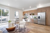 Located at 2408 S Broadway in Boise, Idaho, this well-designed 1-bedroom, 1-bathroom unit offers a thoughtful single-floor layout that maximizes every inch of its space. The open-concept living, dining, and kitchen area serves as the heart of the home, bathed in natural light streaming through large windows and a sliding glass door that frames pleasant outdoor views. Light-toned luxury vinyl plank flooring runs throughout the main living areas, lending a clean, cohesive aesthetic.

The kitchen is a standout feature, outfitted with warm wood-grain cabinetry, white quartz countertops, matte black hardware, and a full suite of stainless steel appliances including a refrigerator with ice maker, electric range, microwave, and dishwasher. The adjoining dining area provides a comfortable space for everyday meals.

The bedroom is a calm retreat with soft carpet underfoot, neutral walls, and access to two closets offering ample storage. The bathroom features a full tub-shower combination with clean white tile surround and modern matte black fixtures. A dedicated laundry room houses a full-size Whirlpool front-load washer and dryer. Recessed lighting and a textured ceiling complete the fresh, contemporary feel throughout this efficiently laid-out Boise residence.