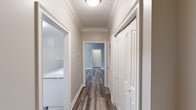 Located at 244 Kyser Blvd in Madison, Alabama, this single-floor, two-bedroom, two-bathroom home offers a thoughtfully designed layout across a comfortable and functional floor plan. The kitchen is a standout feature, outfitted with white shaker-style cabinetry, granite-look countertops, a white subway tile backsplash, and stainless steel appliances including a refrigerator, range, and over-the-range microwave. Light wood-tone flooring runs throughout the kitchen and main living areas, lending a clean, cohesive feel. The combined kitchen and living room area flows naturally together, with the living room highlighted by a ceiling fan, textured ceiling, and a set of French doors that open to an outdoor balcony or patio, allowing ample natural light. Both bedrooms feature plush carpet, ceiling fans, and windows that bring in natural light. Each bedroom is served by a dedicated walk-in closet with wire shelving systems, providing generous storage. The bathrooms include granite-look countertops consistent with the kitchen, wood-look flooring, and a full soaking tub and shower combination. Neutral gray-toned walls throughout the home create a versatile, move-in-ready aesthetic. Two hallways connect the living spaces efficiently, completing this well-organized and comfortable home.