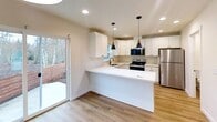 This contemporary residence in Bellingham, Washington, offers 1080 square feet of living space across three floors. The home features two bedrooms, including a primary bedroom of 120 square feet, and three full bathrooms. The ground floor spans 400 square feet, as does the second floor, while the top floor measures 270 square feet.

The kitchen is a highlight, boasting crisp white cabinetry, stainless steel appliances, and a practical L-shaped layout with a peninsula. Recessed lighting and pendant fixtures provide ample illumination, complemented by natural light from a window over the sink. The kitchen's hardwood flooring extends into adjacent areas, creating a cohesive look.

Bedrooms are carpeted for comfort and feature large windows that flood the spaces with natural light. The bathrooms are modern and functional, with one showcasing a sleek walk-in shower. The home also includes a loft area, adding versatility to the living space.

Throughout the property, neutral tones dominate, creating a bright and airy atmosphere. The use of white walls and ceilings maximizes the sense of space and light. Additional features include a hallway and closet space for storage needs.

Located at 282 Tull Pl, this property combines modern amenities with a practical layout, making it an attractive option in the Bellingham real estate market.