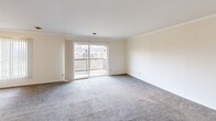 Located on Mersey Lane in Lansing, Michigan, this single-floor residence offers three bedrooms, three bathrooms, and a thoughtfully arranged layout. The entrance opens into a tiled foyer that transitions into a carpeted combined living and dining area. This open space is bright and airy, with large sliding glass doors leading to a private balcony that provides views of the surrounding neighborhood. Crown molding adds a clean, finished look throughout.

The kitchen is efficiently designed with white cabinetry, dark countertops, a mosaic tile backsplash, tile flooring, and white appliances including a refrigerator, range, microwave, and dishwasher. An adjacent pantry provides additional storage. A dedicated laundry room houses a full-size washer and dryer, adding everyday convenience.

The three bedrooms are carpeted and feature warm-toned wood sliding closet doors and ceiling fans. The generously sized primary bedroom offers comfortable proportions with ample closet space. The three bathrooms are finished in white with tile flooring, and at least one includes a tub-shower combination with sliding glass doors and a single-sink vanity. A hallway connects the bedrooms and bathrooms, and five closets throughout the unit ensure abundant storage.