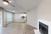 Located at 600 Legacy Dr in Plano, TX, this single-story residence offers a thoughtfully designed layout across one bedroom and one bathroom. The open-concept living and dining areas are anchored by a clean-lined fireplace and finished with light wood-look flooring that extends throughout, creating a cohesive and airy feel. A ceiling fan overhead and a large sliding glass door with vertical blinds allow natural light to fill the dining area, which flows seamlessly into the living space. The kitchen features white shaker cabinetry, light quartz countertops, a gray subway tile backsplash, and a full suite of stainless steel appliances including a refrigerator, electric range, and over-the-range microwave. A peninsula with a built-in sink provides additional prep space and casual seating potential. The spacious bedroom is carpeted for comfort, with a window for natural light and direct access to two closets and the bathroom. The bathroom includes a full tub-shower combo with white tile surround. Additional conveniences include in-unit laundry and a textured ceiling throughout. The neutral color palette and modern finishes create a clean, move-in-ready atmosphere.