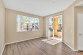 Located at 28520 Wood Canyon Dr in Aliso Viejo, CA, this one-bedroom, one-bathroom single-story home offers a well-organized and efficient layout. The living room features light hardwood-style flooring and vaulted ceilings that lend a sense of openness and airiness. Large windows invite generous natural light and offer views of the surrounding greenery and neighborhood. The kitchen is appointed with white cabinetry, granite-style countertops, a stainless steel sink, and includes a built-in microwave and electric range, along with a full-height pantry cabinet providing ample storage. A peninsula counter connects the kitchen to the living area, enhancing the open flow of the space. The bedroom is comfortably sized, finished with plush carpeting, and features a window with an outdoor view, creating a calm and restful atmosphere. A dedicated closet provides organized storage. The bathroom is well-equipped with a full tub-shower combination featuring white tile surround, a granite-topped vanity, a wide mirror, and hardwood-style flooring. Neutral warm-toned walls throughout create a cohesive and inviting aesthetic, making this a practical and comfortable home in a desirable Southern California location.