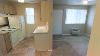 This single-floor space offers a practical and straightforward layout designed for comfortable everyday living. The kitchen is positioned at the heart of the unit, featuring light-toned cabinetry, a countertop with an integrated sink, and tile flooring that provides easy maintenance. A full-size refrigerator anchors one end of the kitchen, while overhead cabinetry offers ample storage. A partial wall divides the kitchen from the adjoining living area, creating a semi-open concept that maintains a sense of connection between the two spaces. The living area transitions to carpet flooring, adding warmth underfoot, and is served by a wall-mounted HVAC unit for climate control. Natural light plays a significant role throughout the space, with multiple windows dressed in vertical blinds allowing bright, diffused light to fill the rooms. The textured ceilings are consistent throughout, lending a cohesive look to the interior. The front entry door is centrally positioned and accessible directly from the living area, offering a welcoming and straightforward entry point. Overall, the space presents a clean, functional environment well-suited for those seeking a no-frills, move-in-ready layout.