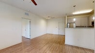 This well-appointed 2-bedroom, 2-bathroom residence in Savannah, GA offers a thoughtfully designed single-floor layout with consistent wood-style flooring throughout. The open-concept living and dining area is bright and airy, featuring a ceiling fan, track lighting, and direct access to a private patio through a glass door, bringing in generous natural light and outdoor views. The kitchen is a standout feature, showcasing white shaker cabinetry, granite countertops, a full suite of stainless steel appliances — including a refrigerator, range, microwave, and dishwasher — and a peninsula with pendant lighting that connects the kitchen to the living area. Both bedrooms are comfortably sized, each offering ceiling fans and large windows with views of lush greenery. The primary bedroom includes a spacious walk-in closet with wire shelving for ample storage. The primary bathroom features a granite-topped vanity and a walk-in shower, while the second bathroom is equipped with a combined tub/shower, granite vanity, and a stacked in-unit washer and dryer. Clean neutral tones and modern finishes create a cohesive, move-in ready ambiance throughout the home.