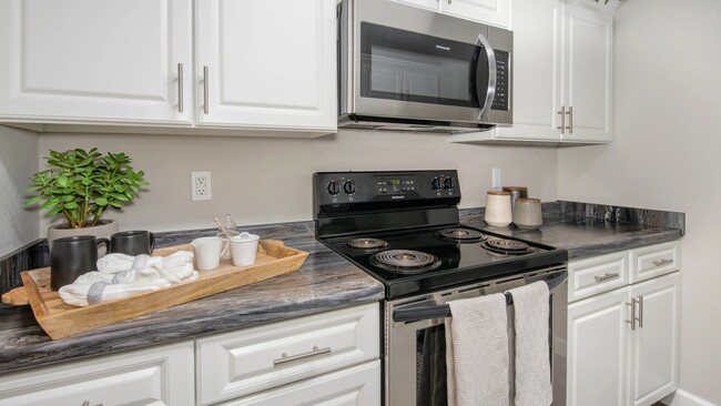 Elevate your culinary adventures in our sleek galley-style kitchen, featuring stainless steel appliances and modern convenience. Cooking here is a joy! - Atlas North