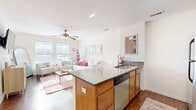 Located at 2710 Stratford Ave in Cincinnati's Clifton Heights neighborhood, this two-bedroom, two-bathroom unit offers a well-designed single-floor layout. The open-concept living and kitchen area serves as the heart of the home, featuring warm hardwood flooring, a ceiling fan, and large windows that flood the space with natural light and offer views of the surrounding cityscape. The kitchen is equipped with stainless steel appliances, granite countertops, warm-toned wood cabinetry, and a peninsula with bar seating — ideal for casual dining or entertaining. Both bedrooms are carpeted and generously sized, each with windows that bring in ample daylight. The primary bedroom provides comfortable space for a full furniture arrangement. Both bathrooms are finished with granite-topped vanities and tile flooring; one features a shower-tub combination. The unit includes four closets, offering notable storage throughout. A second kitchen area adds further functional flexibility. With a bright, neutral palette and a layout that balances open shared spaces with private retreats, this unit delivers a practical and comfortable living environment in Cincinnati.