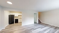 Located at 1699 Shanley Dr in Columbus, Ohio, this two-story home offers a well-organized layout spread across two distinct levels. The main floor features an open living area with light gray wood-look flooring that extends throughout, creating a clean and cohesive feel. The kitchen is positioned adjacent to the living space and is outfitted with white shaker-style cabinetry, granite-look countertops, a stainless steel sink, and black appliances including an electric range, dishwasher, and over-range microwave. A carpeted staircase connects the main level to the upper floor. The upper level includes carpeted bedrooms that receive natural light through large windows fitted with horizontal blinds. One bedroom also features a wall-mounted air conditioning unit. The upper level is also home to a uniquely shaped bathroom with a vaulted, angled ceiling, a white vanity with a framed mirror, wood-look flooring, and a dedicated laundry area. An additional bathroom on the lower level includes a full tub-shower combo with white surround panels and wood-look flooring. Throughout the home, neutral wall tones and clean white trim contribute to a bright, move-in ready atmosphere.