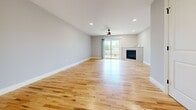 This well-appointed three-floor home offers 2 bedrooms and 3 full bathrooms, thoughtfully designed with modern finishes and a functional layout. The main living level features an open-concept kitchen and living area with light hardwood flooring that flows throughout. The kitchen is equipped with stainless steel appliances, gray shaker-style cabinetry accented by matte black hardware, white quartz countertops, a subway tile backsplash, and a peninsula with pendant lighting — ideal for everyday living and entertaining. The spacious living room features a fireplace, ceiling fan, recessed lighting, and sliding glass doors that open to an outdoor deck, filling the space with natural light. The upper floor houses both bedrooms, including a generously sized primary bedroom with plush carpeting and a ceiling fan. The second bedroom also features carpet flooring and large windows. All three bathrooms are finished with gray vanities, white quartz countertops, and matte black fixtures. The lower level provides an additional living area with wood-look flooring and recessed lighting, offering flexible space for a recreation room or home office. Staircases connect all three levels seamlessly throughout this clean, contemporary home.