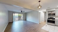 This thoughtfully updated 2-bedroom, 2-bathroom home in Pikesville, MD offers a clean, modern aesthetic throughout its efficiently designed single-floor layout. The open living room is anchored by durable hardwood-style flooring, a contemporary ceiling fan, and a globe pendant light fixture. A sliding glass door fills the space with natural light and provides direct access to the outdoors, where lush greenery creates a pleasant view.

The kitchen is a standout feature, outfitted with gray shaker-style cabinetry, white quartz countertops, a classic subway tile backsplash, and a full suite of stainless steel appliances including a gas range, microwave, dishwasher, and refrigerator. Large-format marble-look tile flooring completes the polished look. A hallway off the kitchen reveals an in-unit stacked washer and dryer, adding everyday convenience.

Both bedrooms are bright and comfortable, featuring hardwood-style flooring and windows that bring in natural light. The two bathrooms are finished with matching marble-look tile on both the floors and tub surrounds, paired with brushed nickel fixtures for a cohesive, refined look. Two closets provide ample storage throughout the home. Neutral tones and clean finishes give the entire space a move-in-ready feel.