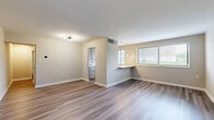 Located at 3317 Walters Ln in District Heights, MD, this single-floor, 4-bedroom, 1-bathroom home offers a thoughtfully updated interior with contemporary finishes throughout. The open-concept living room and kitchen area is anchored by warm wood-look laminate flooring, neutral-toned walls, and abundant natural light streaming through multiple windows fitted with blinds. A built-in breakfast bar with pendant lighting creates a seamless transition between the living and kitchen spaces. The kitchen is well-appointed with white subway tile backsplash, crisp white quartz countertops, light grey shaker-style cabinetry, and stainless steel appliances including a gas range, microwave, and dishwasher. Each of the four bedrooms features plush carpeting, neutral walls, and windows that bring in natural light with views of the surrounding greenery. The generously sized primary bedroom offers ample space for comfortable furnishings. Two closets provide convenient storage throughout the home. The bathroom is a standout feature, showcasing floor-to-ceiling marble-look tile in the tub and shower surround, accented by matte black hardware, a white vanity, and wood-look tile flooring — a refined, modern aesthetic that elevates the overall space.