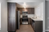 Located at 310 S Jefferson St in Placentia, California, this single-floor residence offers a well-organized layout designed for comfortable everyday living. The kitchen is a standout feature, outfitted with a full suite of stainless steel appliances including a refrigerator, electric range, microwave, and dishwasher. Rich wood-toned cabinetry, a clean white countertop, a subway tile backsplash, and track lighting come together to create a functional and modern cooking space. A window with horizontal blinds allows natural light to brighten the room.

The living area features wood-style tile flooring and neutral taupe walls, creating a warm and versatile atmosphere. A sliding glass door fitted with vertical blinds opens to an outdoor area, allowing for natural light and easy exterior access. The open layout connects seamlessly to adjoining spaces, enhancing the overall flow of the home.

The bedrooms are finished with plush carpeting and neutral tones, providing a comfortable and quiet retreat. One bedroom also features a sliding glass door with access to an outdoor space. The bathroom is cleanly appointed with a tub-shower combination, wood-look flooring, and a vanity with dark cabinetry, complemented by a small window for ventilation and natural light.