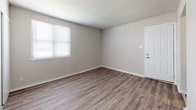 Located at 523 Summit St in Petersburg, Virginia, this single-floor residence offers a straightforward and functional layout across several well-defined living spaces. The interior features consistent wood-look laminate flooring throughout the main living and bedroom areas, providing a warm and cohesive aesthetic. Neutral gray-toned walls complement the flooring and create a clean, move-in-ready atmosphere.

The kitchen area is equipped with standard appliances, including a refrigerator and stove, set against white cabinetry. The kitchen transitions into an adjacent area finished with distinctive multi-toned stone tile flooring, adding visual contrast and character to that portion of the home.

Multiple rooms throughout the residence are brightened by windows fitted with blinds, allowing for adjustable natural light and views of the surrounding neighborhood. One of the bedrooms includes a closet, offering practical storage solutions. The rooms are generously proportioned with clean white trim and smooth walls.

The bathroom is outfitted with a full tub and shower combo featuring white surround panels, brushed nickel fixtures, a white vanity, and the same stone tile flooring seen in the kitchen area, tying the two spaces together cohesively.

Overall, this residence presents a clean, updated interior with consistent finishes, functional room layouts, and ample natural light throughout.