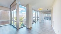 This modern 800 square foot apartment maximizes space with its efficient single-floor layout. The heart of the home is an expansive open-concept area combining the kitchen and living room, creating a seamless flow for entertaining and daily life. Floor-to-ceiling windows dominate the space, flooding the interior with natural light and providing breathtaking panoramic views of the city skyline and nearby park greenery.

The apartment features sleek, contemporary finishes throughout. Light-toned wood flooring extends across the living areas, enhancing the sense of spaciousness. Strategically placed columns define the space without obstructing the open feel. Motorized roller shades offer privacy and light control when desired.

A well-appointed bathroom and separate laundry area add convenience to the floor plan. While compact, the 800 square foot layout is thoughtfully designed to feel much larger, with the stunning views and abundance of natural light contributing to an airy, expansive atmosphere. This apartment seamlessly blends urban living with a connection to nature, offering a tranquil retreat in the heart of the city.