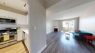 Located at 627 N Rossmore Ave in the Larchmont Village neighborhood of Los Angeles, this single-story unit offers a well-designed layout with modern finishes throughout. The open living area is highlighted by grey-toned hardwood-style flooring, a classic fireplace with a white mantle, and a large sliding glass door that invites abundant natural light and outdoor views. The space flows seamlessly from the living area into the kitchen, which features white cabinetry, white countertops, and stainless steel appliances including a gas range and over-the-range microwave. The bedrooms are generously sized, each featuring the same hardwood-style flooring and windows fitted with blinds that allow for natural light while maintaining privacy. One bedroom is equipped with a ceiling fan for added comfort. The bathrooms are clean and functional, each offering a full shower-tub combination with chrome fixtures and white tile surrounds. A dedicated laundry area with a washer and dryer is also present within the unit. The overall aesthetic is clean, neutral, and move-in ready, with light grey walls and white trim providing a cohesive and contemporary feel throughout the space.