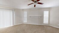 Located at 1100 Langwick Dr in Houston, TX, this single-floor 2-bedroom, 1-bathroom home offers a practical and comfortable layout designed for everyday living. The galley-style kitchen is a standout feature, boasting white cabinetry, granite-look countertops, light tile flooring, and a full suite of stainless steel appliances including a range, microwave, refrigerator, and dishwasher. The layout flows efficiently through a connecting hallway that links the main living areas to the bedrooms and bathroom. The primary bedroom is a generous, well-lit space featuring soft carpeting, crown molding, a ceiling fan with light fixture, a decorative wall-mounted shelf, and multiple windows with blinds that allow natural light to fill the room. A sliding vertical blind panel provides access to an additional area. The second bedroom is cozy and carpeted, with a ceiling fan and a window overlooking the exterior. Both bedrooms are served by two dedicated closets. The bathroom is clean and functional, equipped with a full soaking tub and shower combination with built-in wall niches. Throughout the home, neutral tones and clean white trim create a bright, cohesive ambiance.