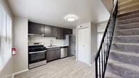 This two-story home in Halethorpe, MD offers a functional and well-organized layout spread across two floors. The main level features a modern kitchen equipped with stainless steel appliances — including a gas range, dishwasher, and refrigerator — complemented by dark cabinetry, light countertops, and light wood-look flooring. A large sliding glass door in the adjacent living area fills the space with natural light and provides outdoor views. A closet and hallway complete the main floor layout.

Upstairs, three carpeted bedrooms offer comfortable, versatile spaces. The generously sized primary bedroom provides ample room, while the two additional bedrooms each feature neutral tones, carpet flooring, and windows that bring in natural light with neighborhood views. Two closets throughout the upper level provide convenient storage.

The full bathroom is finished with wood-look flooring, a tub/shower combo with a curved curtain rod, and clean white fixtures. The overall aesthetic throughout the home is clean and neutral, with light walls and practical finishes that create a bright, move-in-ready environment suited for a variety of living arrangements.