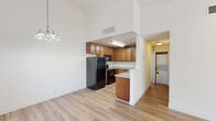 Located on Calle Albara in El Cajon, CA, this one-bedroom, one-bathroom residence offers a thoughtfully laid-out single-level floor plan. The open living room is a standout space, featuring light-toned hardwood flooring, crisp white walls, and a charming fireplace with a terra cotta tile surround and white mantle. Sliding glass doors flood the room with natural light and provide direct access to a private balcony with views of surrounding greenery, creating a seamless indoor-outdoor connection. The kitchen is efficiently designed in a U-shape layout, offering rich warm-toned cabinetry, granite countertops, a stainless steel sink, and black appliances, including a full-size refrigerator. The bedroom is a comfortable, quiet retreat with plush carpeting, a window overlooking outdoor landscaping, and ample wall space for furnishings. The bathroom is clean and functional, featuring a full tub-shower combination with white surrounds. Throughout the home, recessed lighting, window blinds, and a neutral color palette contribute to a bright, move-in-ready atmosphere suited for comfortable everyday living in the San Diego East County region.