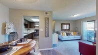 Located at 267 Zang St in Lakewood, Colorado, this single-floor residence offers a thoughtfully designed layout with a seamless flow between living, dining, and kitchen spaces. The open-concept living area is carpeted and features neutral warm-gray walls, a textured ceiling, and generous natural light, creating a welcoming and comfortable atmosphere.

The kitchen is well-appointed with rich dark espresso cabinetry, stainless steel appliances including a range and refrigerator, light countertops, a double-basin sink, and a skylight that fills the space with additional natural light. Wood-look flooring ties the kitchen and dining areas together cohesively.

The dining area accommodates a round table and provides a cozy, defined space for meals. The primary bedroom offers plush carpeting, neutral walls, and direct access to a private en-suite or adjacent bathroom. A second bedroom features carpeting, a window with natural light, and versatile space suitable for a variety of uses.

The bathroom includes a full tub and shower combination, a vanity with dark cabinetry, and wood-look flooring. A dedicated in-unit laundry area with full-sized washer and dryer hookups adds significant convenience. Overall, the residence presents a practical and comfortable living environment in the heart of Lakewood.
