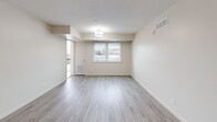 This well-appointed 2-bedroom, 1-bathroom unit at 772 Paisley Rd in Guelph, Ontario offers a thoughtfully designed layout with modern finishes throughout. The open-concept kitchen and living area serves as the heart of the unit, featuring a large island with a sleek grey quartz countertop and undermount sink, white cabinetry, a full suite of stainless steel appliances, and stylish pendant lighting. The living area is bright and airy, with large windows that invite natural light and provide outdoor views, complemented by light wood-look flooring that extends throughout the unit. A private balcony adds additional outdoor space. Both bedrooms are comfortably sized, finished with the same light flooring and windows, offering a clean, neutral palette. The bathroom features a white vanity with a large mirror and bright lighting, alongside a well-organized closet with built-in shelving. A dedicated in-unit laundry room provides added convenience with a full-sized washer and dryer. The hallway connects all rooms efficiently, with two closets offering generous storage. The unit's consistent use of neutral tones, modern fixtures, and functional spaces creates a clean and contemporary living environment.