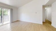 This thoughtfully designed 2-bedroom, 2-bathroom unit in Woodland, CA offers a clean, modern aesthetic throughout its well-utilized single-floor layout. Light wood-style flooring flows seamlessly through every room, creating a bright and cohesive feel.

The kitchen is a standout feature, showcasing two-tone cabinetry with crisp white upper cabinets and navy lower cabinets, complemented by marble-look countertops and a full suite of stainless steel appliances including a gas range, refrigerator, and dishwasher. A skylight adds additional brightness to the space.

The open living room is airy and sun-filled, with sliding glass doors leading to a private balcony that overlooks lush greenery — an ideal spot for enjoying outdoor views. The spacious primary bedroom connects directly to its own en-suite bathroom, which features dark cabinetry, a wide vanity mirror, and a shower/tub combination. The second bedroom also benefits from natural light through a window with vertical blinds and tree-lined views. The second bathroom mirrors the clean, white aesthetic with a shower/tub combo and neutral finishes.

A hallway connects the rooms efficiently, and the overall design emphasizes simplicity, functionality, and modern comfort throughout.