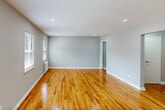 Located at 123 Davey Street in Bloomfield, NJ, this 2-bedroom, 1-bathroom residence offers a thoughtfully designed single-floor layout that maximizes every square foot. Warm-toned hardwood flooring runs throughout the living areas and bedrooms, lending a cohesive and inviting feel to the entire space. Neutral gray walls and clean white trim provide a modern, versatile backdrop.

The living room is bright and open, featuring recessed lighting and a white entry door that adds a crisp, clean aesthetic. Natural light filters in through windows fitted with blinds, enhancing the airy atmosphere. A hallway connects the main living area to the rest of the home.

The primary bedroom is generously sized, offering two windows with neighborhood views and a classic cast-iron radiator, while the second bedroom provides a comfortable and functional space with its own window and radiator. Both rooms continue the hardwood flooring found throughout.

The kitchen is well-appointed with dark cabinetry, marble-look countertops, stainless steel appliances including a gas range and dishwasher, and light porcelain tile flooring. A window above the sink area brings in natural light.

The bathroom is a standout feature, finished with floor-to-ceiling marble-look tile, a soaking tub, and a bright window, creating a clean, spa-like atmosphere.