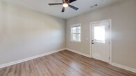 Located at 601 Outlook Dr in Grovetown, GA, this single-story 2-bedroom, 2-bathroom home offers a well-designed layout with modern finishes throughout. The open-concept kitchen and living area is anchored by a stylish kitchen featuring white shaker cabinetry, granite countertops, a stainless steel appliance suite including a refrigerator, range, microwave, and dishwasher, and wood-look flooring that extends through the main living spaces. The living area is bright and airy, with a ceiling fan, a windowed entry door, and natural light flowing in from multiple windows. Both bedrooms are carpeted and generously sized, with large windows offering neighborhood views and ceiling fans for year-round comfort. The spacious primary bedroom includes access to multiple closets, one of which is a walk-in with wire shelving. The two bathrooms are finished with granite-topped white vanities and wood-look flooring; one includes a tub/shower combo. A dedicated in-unit laundry room accommodates a full-size washer and dryer set. Clean neutral wall tones, white panel doors with matte black hardware, and crisp white trim unify the home's contemporary aesthetic throughout.