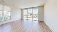 Located at 833 W Main St, Unit 301 in Carmel, Indiana, this three-bedroom, two-bathroom residence offers a well-designed single-floor layout with clean, modern finishes throughout. Light-toned hardwood-style flooring runs continuously across the entire unit, contributing to a bright and cohesive aesthetic.

The open-concept kitchen and living area serves as the heart of the home. The kitchen features white shaker cabinetry extending to the ceiling, stainless steel appliances, light quartz countertops, a center island with a sink, and stylish pendant lighting — ideal for both everyday living and entertaining.

The spacious primary bedroom is filled with natural light from large windows overlooking the surrounding neighborhood and benefits from a dedicated walk-in closet outfitted with built-in shelving and double hanging rods. The en-suite bathroom includes a white vanity with quartz counters and a glass-enclosed walk-in shower with light wood-look flooring. The secondary bathroom offers a full tub-shower combo with white tile surround.

The two additional bedrooms each feature ceiling fans, natural light from windows with outdoor views, and easy access to the shared bathroom. A dedicated laundry area accommodates a full-size washer and includes overhead shelving for added storage. The unit also includes two closets, providing ample organizational space throughout.
