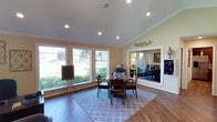 This single-floor residence offers a thoughtfully designed layout that balances comfort and functionality throughout. The living room serves as the heart of the home, featuring plush carpeting, warm neutral walls, and a cozy atmosphere highlighted by tasteful wall art. It flows seamlessly into the dedicated dining area, which is illuminated by an elegant multi-pendant chandelier and comfortably accommodates a round glass-top dining table — ideal for everyday meals or entertaining guests.

The kitchen is efficiently arranged with white cabinetry, matching white appliances including a coil-top range and full-size refrigerator, and durable hardwood-style flooring, providing a clean and practical cooking space. A convenient pass-through connects the kitchen to the living area.

The primary bedroom is generously sized, featuring soft carpeting, a ceiling fan with light fixture, and a window that allows natural light to filter in. A second bedroom offers similar comforts, complete with its own ceiling fan, a walk-in closet, and ample space for flexible use.

The bathroom is clean and well-appointed, featuring a single-sink vanity with white cabinetry, a large mirror, and a shower-tub combination. Rounding out the home is a dedicated in-unit laundry area with washer and dryer hookups, adding everyday convenience to this move-in-ready residence.
