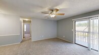 Located at 617 Richardson St in Simpsonville, SC, this 2-bedroom, 2-bathroom residence offers a well-organized single-floor layout designed for comfortable everyday living. The open-concept living and dining area features soft carpeting, a ceiling fan, and a sliding glass door that opens to a private balcony, allowing natural light to fill the space and providing pleasant outdoor views.

The kitchen is equipped with warm wood-toned cabinetry, a range, refrigerator, dishwasher, and a sink, with durable light-toned flooring underfoot. Track lighting and under-cabinet ventilation add to its functional design. The kitchen flows naturally into the living area, making it ideal for entertaining.

Both bedrooms are carpeted and feature ceiling fans with light fixtures. The primary bedroom is generously sized, offering two closet doors and direct access to one of the two bathrooms. The second bedroom includes a window that brings in natural light, adding to its airy feel.

Each bathroom is outfitted with a tub-shower combination, wood-toned vanity cabinetry, and light hardwood-style flooring. A dedicated laundry area and closet round out the unit's practical amenities. Neutral gray walls throughout create a clean, cohesive aesthetic across all rooms.