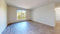 Located at 735 Wonderland Rd S in London, Ontario, this well-appointed two-bedroom, one-bathroom unit offers a thoughtfully organized layout across a single floor. Light-toned hardwood flooring flows consistently throughout the space, creating a clean and cohesive aesthetic that enhances the bright, neutral interior.

The kitchen is equipped with stainless steel appliances — including a fridge, stove, and over-the-range microwave — complemented by white shaker-style cabinetry and a subway tile backsplash. It connects conveniently to a dedicated dining area, making everyday living and entertaining straightforward. The adjacent living room is generously proportioned, bathed in natural light from a large sliding window that opens to a private balcony with leafy outdoor views.

Both bedrooms feature light hardwood flooring, windows overlooking greenery, and baseboard heating. The primary bedroom is a comfortable size and includes a closet with sliding doors. Additional closet storage is found throughout the unit, with five closets in total offering excellent organizational capacity.

The bathroom is finished with large-format tile flooring, a full soaker tub with a glass-panel shower surround, a white vanity, and clean white walls. A dedicated entrance provides a practical transition point into the home. The overall ambiance is bright, clean, and move-in ready.