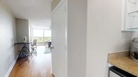 Located at 1860 Fairfield Ave in Shreveport, Louisiana, this efficiently designed studio offers a single-floor layout that maximizes every square foot. The open living area is anchored by warm hardwood flooring that runs throughout, complemented by neutral-toned walls and a textured ceiling. A floor-to-ceiling sliding glass door floods the space with abundant natural light and opens to a balcony with elevated views of the surrounding treetops and neighborhood below, creating a bright and airy atmosphere.

The living area is thoughtfully arranged to accommodate both lounging and dining, with space for a sofa, coffee table, and a bistro-style high-top table and stools. A full wall of built-in white cabinetry with drawers provides generous storage without sacrificing floor space. A dedicated built-in desk nook with overhead cabinetry and a granite-style countertop offers a functional workspace tucked neatly into the room. A ceiling fan adds comfort overhead.

The bathroom is clean and well-appointed, featuring light tile flooring, a pedestal sink, a medicine cabinet mirror, and a full tub-shower combination with white tile surround. The overall design of the space is practical and cohesive, making it well-suited for efficient, comfortable living.