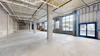 Located at 77 William St in Belleville, NJ, this ground-floor commercial shell space presents a rare opportunity for tenants or developers seeking a large, open-plan canvas in a modern building. The space is delivered in raw shell condition, showcasing its structural bones — exposed concrete masonry unit walls, polished concrete slab flooring, and a grid of structural concrete columns that define the open floor plan without interrupting its generous sense of volume.

The ceiling is left open to the structural deck above, with overhead plumbing, conduit runs, and mechanical infrastructure already roughed in, streamlining future buildout. Large steel-framed windows line key portions of the perimeter, allowing substantial natural light to flood the interior and offering street-level views of the surrounding Belleville neighborhood.

Multiple entry points with steel-framed glass storefronts are visible, enhancing accessibility and street presence. The long, rectangular footprint — clearly visible in the 3D overview — lends itself to a variety of commercial configurations, from retail and showroom to food and beverage, medical, or office use. The industrial aesthetic, combined with the raw, flexible layout, provides an ideal blank slate ready for a custom buildout tailored to virtually any commercial vision.