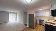 Located at 3051 Kirklevington Dr in Lexington, Kentucky, this single-floor unit offers a well-designed layout that balances functionality with comfort. The open-concept living area is finished with neutral-toned carpet and painted in a soft gray palette, creating a calm and versatile backdrop. A sliding glass door with vertical blinds floods the living space with natural light while providing access to the outdoors.

The kitchen is a standout feature, equipped with stainless steel appliances including a range, microwave, and dishwasher, complemented by a full-size refrigerator. White shaker-style cabinetry, marble-patterned countertops, and a classic white subway tile backsplash give the kitchen a clean, updated aesthetic. Warm wood-tone flooring ties the kitchen seamlessly to the adjoining living space.

The bedroom offers plush carpeting underfoot and exceptional storage, featuring two sets of double bi-fold closet doors that open to reveal generous closet space with dedicated shelving and hanging rods.

The bathroom is finished with a white vanity, brushed nickel fixtures, and a large mirror that enhances the sense of space. Clean, bright walls and efficient lighting complete the room. Throughout the unit, consistent neutral tones and updated finishes contribute to a cohesive, move-in-ready living environment.