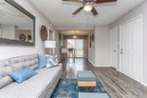 Located at 2074 Forest Hill Rd in Macon, Georgia, this single-floor residence offers a thoughtfully designed layout with a cohesive, modern aesthetic throughout. The living room serves as a welcoming gathering space, featuring rich hardwood-style flooring, bold teal drapery, and a large wall mirror that enhances the sense of openness. A comfortable seating arrangement anchors the room, complemented by tasteful décor and a ceiling fan overhead.

The kitchen is well-equipped and visually striking, showcasing white cabinetry with brushed hardware, granite-look countertops, a gray subway tile backsplash, and black appliances including a range, dishwasher, and refrigerator. The hardwood-style flooring continues seamlessly into this space.

The bedroom is a serene retreat with plush carpeting, ample natural light from a window with greenery views, a ceiling fan, and neutral gray walls that create a calm atmosphere. Generous closet space adds to the room's functionality.

The bathroom features white cabinetry, granite-look countertops, and hardwood-style flooring. A notable highlight is the in-unit washer and dryer conveniently tucked behind louvered closet doors within the bathroom area, offering exceptional practicality. The overall design presents a clean, modern living experience in a comfortable Macon setting.