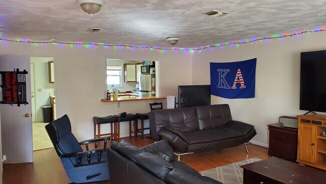 large downstairs living room with laminated floor and bard between room and kutchen - 200 Pheasant Run Dr