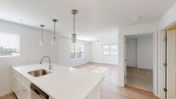 Located at 32015 Azure Ave in Rehoboth Beach, Delaware, this single-floor home offers a clean, modern design with an open and airy layout throughout. The heart of the home is the open-concept kitchen and living area, where light hardwood-style flooring flows seamlessly underfoot. The kitchen is well-appointed with crisp white shaker cabinetry, a mosaic tile backsplash, stainless steel appliances including a refrigerator, range, and microwave, and a generous island featuring a built-in sink and bright white countertops. Stylish pendant lights hang above the island, adding a contemporary touch. The living area extends naturally from the kitchen, bathed in natural light from multiple windows and a set of glass-paneled doors, with a ceiling fan providing added comfort. The bedroom is carpeted and comfortably sized, featuring a ceiling fan, a natural light-filled window, and a double-door closet offering ample storage. The bathroom is well-designed with light hardwood-style flooring, a white vanity with countertop sink, and a full tub and shower combination. Throughout the home, a consistent bright white palette and clean finishes create a fresh, welcoming atmosphere ideal for coastal living near Rehoboth Beach.