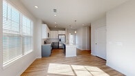 This single-story, 3-bedroom, 2-bathroom home offers a thoughtfully designed layout across a generously sized floor plan. The open-concept kitchen and living area serves as the heart of the home, showcasing warm hardwood-style flooring, recessed lighting, and large windows that flood the space with natural light. The kitchen is well-equipped with two-tone cabinetry — white upper cabinets paired with slate-gray lower cabinets — complemented by a subway tile backsplash, granite-look countertops, stainless steel appliances, and a central island with pendant lighting overhead. The adjacent living and entry areas continue the hardwood-style flooring and feature multiple windows with blinds, creating a bright and welcoming atmosphere. The three bedrooms are carpeted for comfort, each offering ceiling fans and ample natural light. The spacious primary bedroom includes its own closet with built-in wire shelving. The two bathrooms are finished with gray vanity cabinetry, granite countertops, and hardwood-style flooring, maintaining a consistent, modern aesthetic throughout. Three closets, including walk-in storage with wire rack systems, provide excellent organizational capacity. The overall design is clean, contemporary, and move-in ready.
