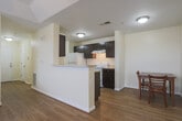 Located in Columbus, GA, this single-story home offers a well-designed, functional layout with a clean and neutral aesthetic throughout. The living area features warm hardwood-style flooring, a ceiling fan, and a large window fitted with horizontal blinds that brings in natural light and outdoor views, creating a comfortable and open atmosphere. Adjacent to the living room, the kitchen is equipped with dark espresso cabinetry, white appliances including a range and refrigerator, and a breakfast bar peninsula that provides additional counter space and separates the kitchen from the dining area. A dedicated dining space with room for a table and chairs sits conveniently nearby. A hallway with hardwood-style flooring connects the main living spaces to the private areas of the home. Both bedrooms are carpeted and feature warm, neutral walls. One bedroom includes a large window with outdoor views, while the other offers a spacious closet with bi-fold doors. Each room is served by a full bathroom appointed with tile flooring, a tub/shower combination, a dark vanity, and clean white fixtures. The home also includes a dedicated laundry room with a full-size washer and dryer, adding significant everyday convenience to this well-appointed residence.