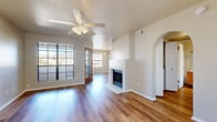 Located at 8115 N 18th St in Phoenix, AZ, this single-story, one-bedroom, one-bathroom home offers a well-organized layout with a comfortable and functional living environment. The open living room is a welcoming centerpiece, highlighted by rich wood-style flooring, a ceiling fan, and a charming tile-surround fireplace that adds character to the space. Large grid-pane windows and a wood-framed French door flood the room with natural light while framing scenic desert mountain views. An elegant arched doorway connects the living area to the rest of the home, adding an architectural touch. The dining room is bright and airy, featuring multiple large windows with mountain views and a stylish chandelier overhead. The kitchen is well-appointed with warm wood cabinetry, stainless steel appliances, and light countertops. The bedroom offers plush carpeting, a ceiling fan, and a window with pleasant outdoor views, while a spacious walk-in closet with wire shelving provides generous storage. The bathroom includes a full tub-shower combination with tiled surround, a wood-toned vanity, and hardwood-style flooring. Throughout the home, neutral tones and consistent flooring create a cohesive, inviting atmosphere.