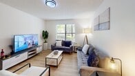 This thoughtfully laid-out 2-bedroom, 2-bathroom residence offers a practical and comfortable single-floor living experience. Light wood-style flooring flows consistently throughout the space, lending a clean, cohesive aesthetic to every room.

The living room is bright and welcoming, featuring a large window that invites natural light and provides views of surrounding greenery. The space comfortably accommodates a full seating arrangement and entertainment setup. Adjacent to the living room, the combined dining and kitchen area is highly functional — the kitchen is outfitted with stainless steel appliances, white cabinetry with modern black hardware, and marble-style countertops, while the dining area offers room for a full dining table.

Both bedrooms are well-proportioned, with the primary bedroom providing ample space for rest and daily use. Each bedroom benefits from windows with outdoor views and textured ceilings. A dedicated walk-in closet provides organized storage.

The two bathrooms are clean and functional, each featuring a tub-shower combination with contemporary black fixtures. In-unit laundry with washer and dryer hookups adds significant convenience. A hallway connects all areas efficiently, completing this practical and comfortable living space.