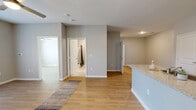 This thoughtfully laid-out single-floor residence offers a comfortable and functional living experience across its one-bedroom, one-bathroom floor plan. The open-concept kitchen and living area form the heart of the home, featuring warm wood-look flooring, neutral gray walls, and a ceiling fan that enhance the bright, airy ambiance. The kitchen is appointed with dark espresso cabinetry, granite countertops, a subway tile backsplash, and a full suite of black appliances including a refrigerator, range, and microwave. A peninsula with a granite surface and integrated sink provides additional prep space and connects seamlessly to the living area. The living room benefits from a large window that invites natural light and is anchored by a ceiling fan for year-round comfort. The bedroom is a well-proportioned retreat with its own ceiling fan, a generous window with natural light, and a walk-in closet with built-in shelving. The bathroom features tile flooring, a combination tub and shower, a large vanity mirror, and dark wood cabinetry topped with granite counters. Clean white trim, consistent flooring, and a cohesive neutral palette create a polished, move-in-ready atmosphere throughout.